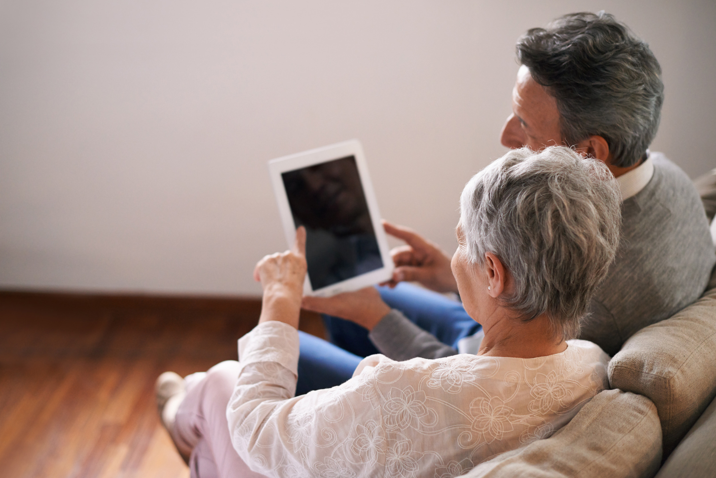 A man and a woman look at an ipad