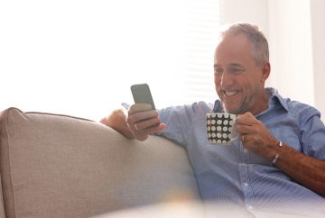 Man smiling holding phone