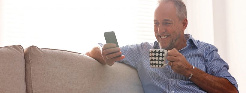 Man smiling holding phone