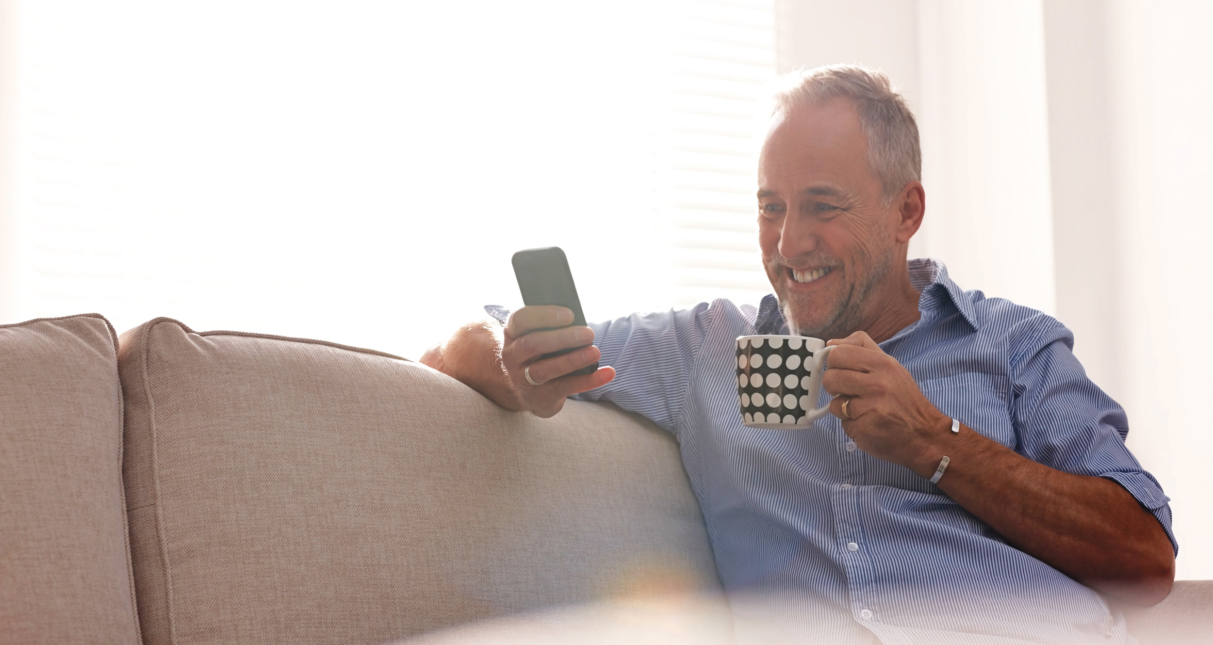 Man smiling holding phone