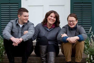 Picture of a woman sitting on her porch with her two sons