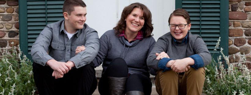 Picture of a woman sitting on her porch with her two sons