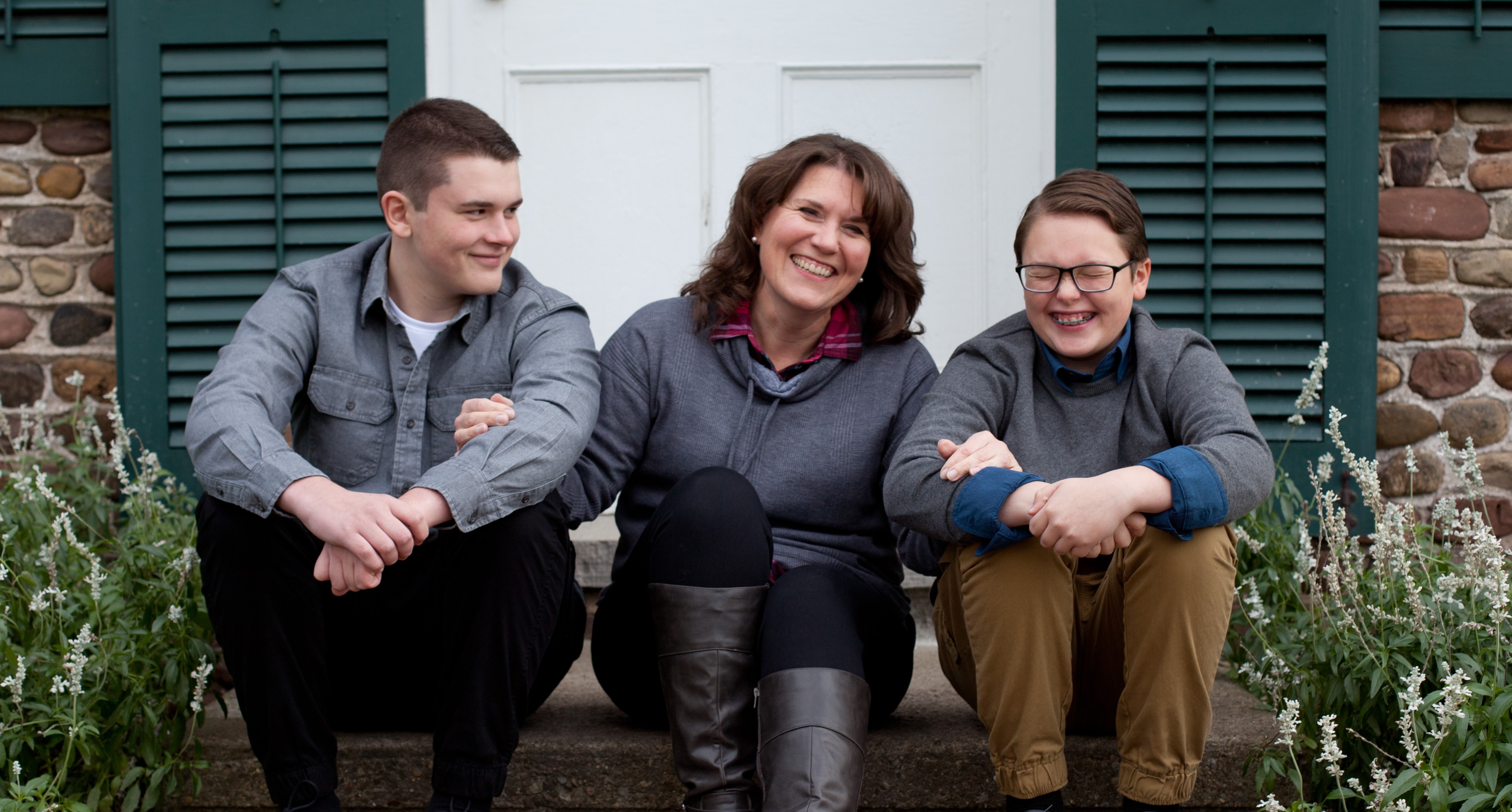 Picture of a woman sitting on her porch with her two sons