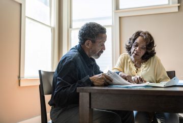 Picture of two adults sitting at a table talking.