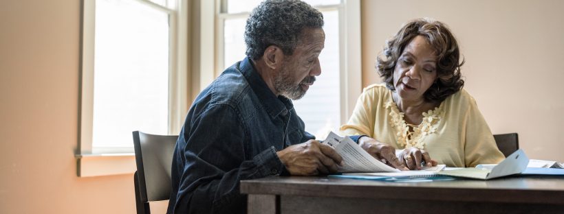 Picture of two adults sitting at a table talking.