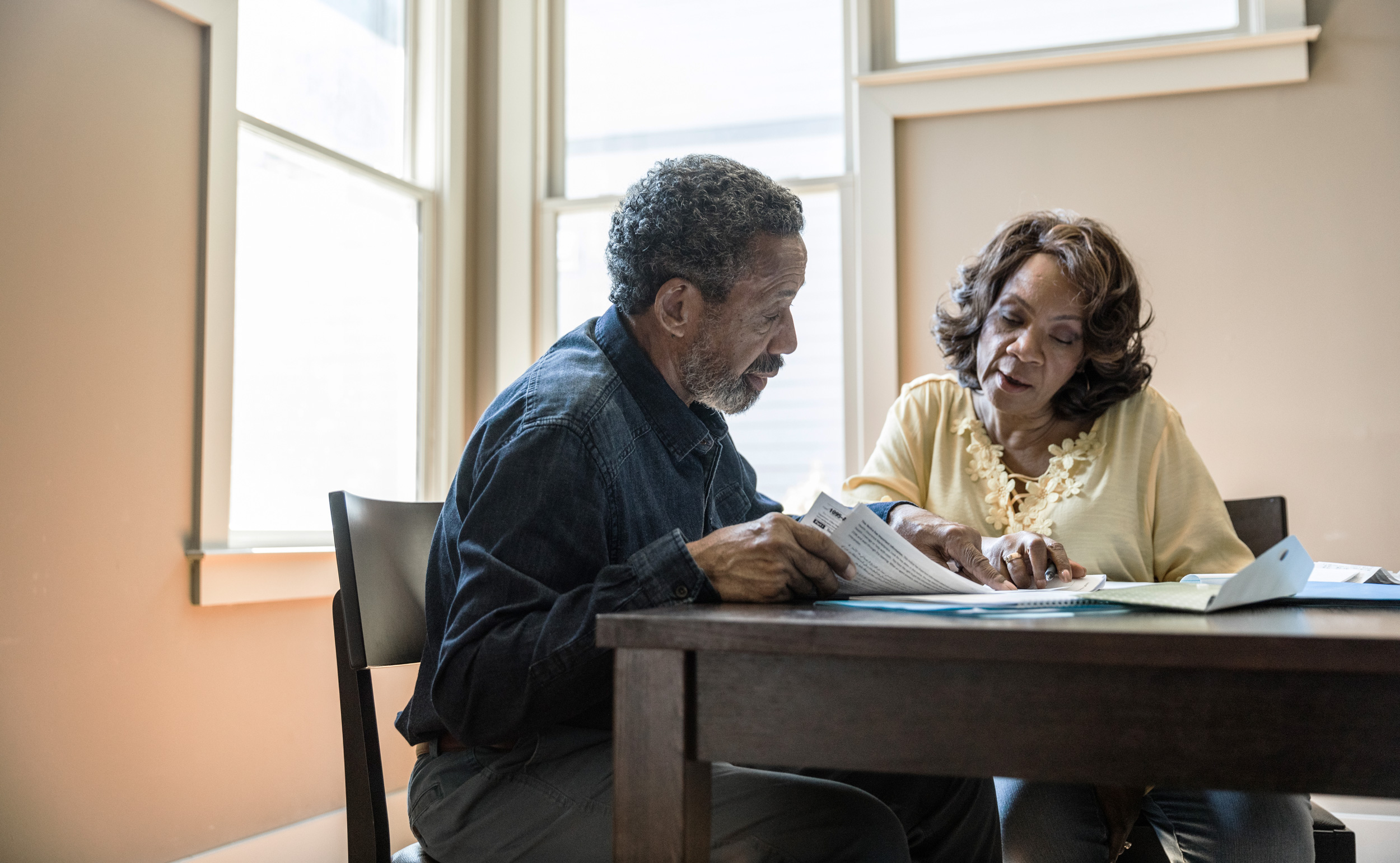 Picture of two adults sitting at a table talking.