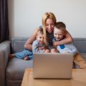 Mother sitting with her two children in front of a computer