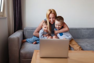 Mother sitting with her two children in front of a computer