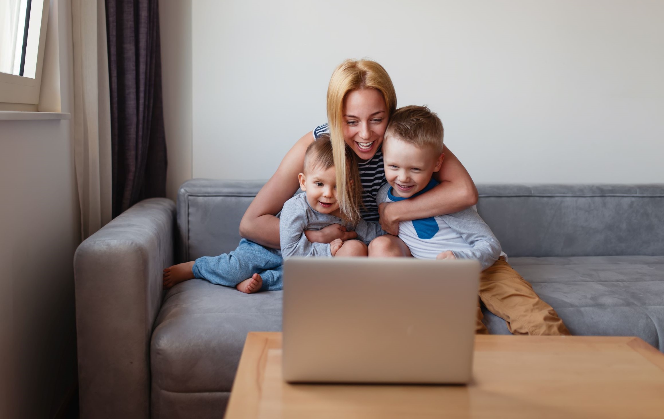 Mother sitting with her two children in front of a computer