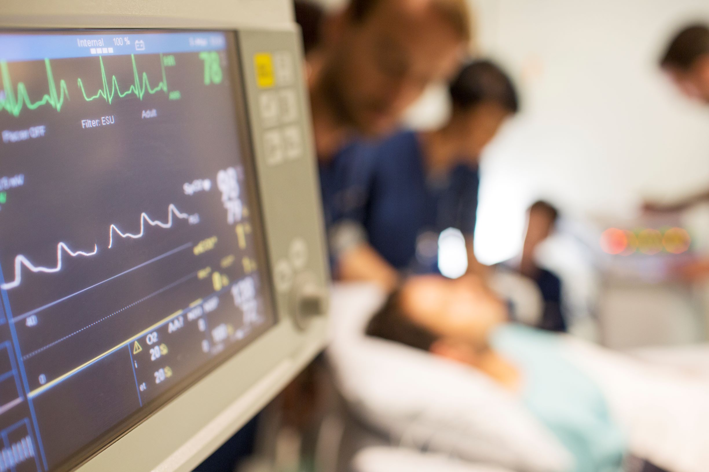 Picture of someone in a hospital bed with medical professionals around them