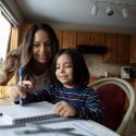 Mother helping child do homework