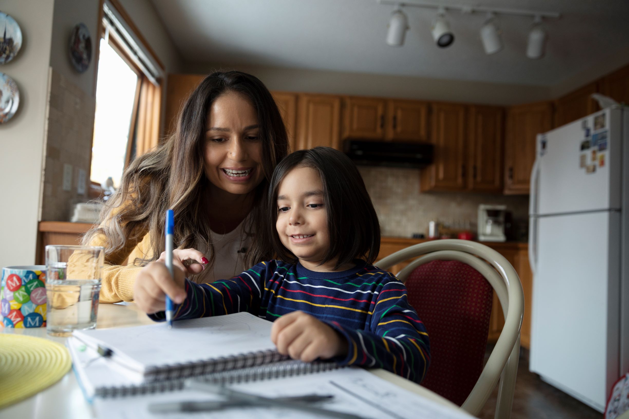 Mother helping child do homework