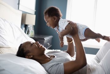 Picture of a mom holding a baby up over her head