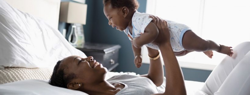 Picture of a mom holding a baby up over her head