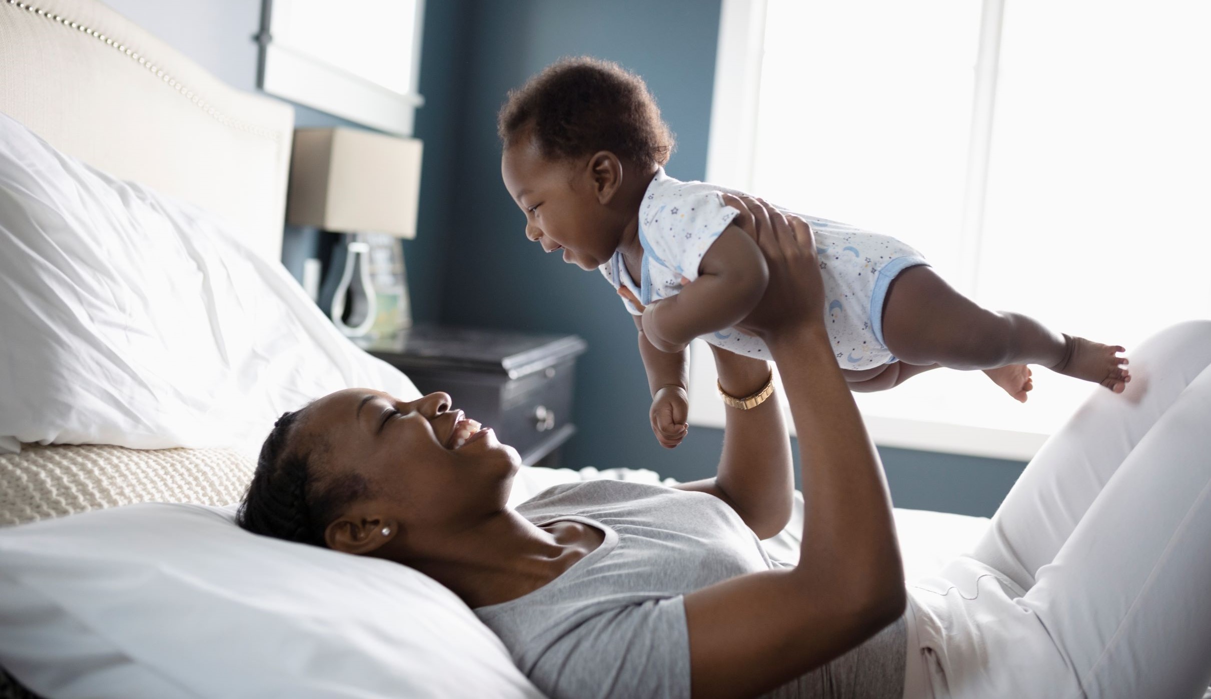 Picture of a mom holding a baby up over her head