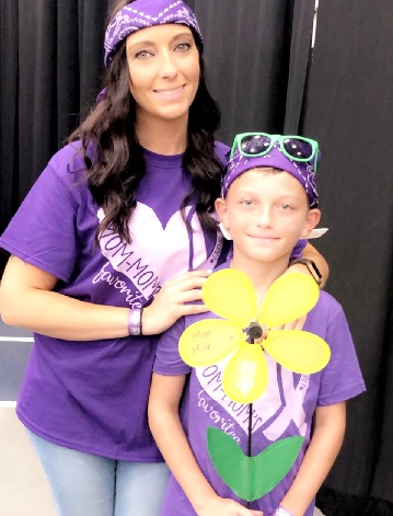 A woman and her son dressed in purple at a community event