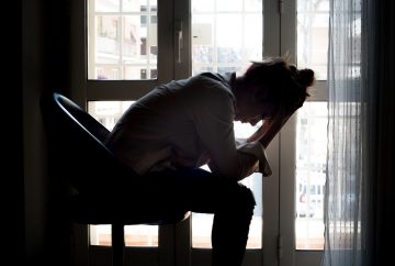 Picture of woman holding her head in her hands