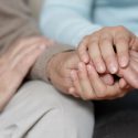 A caregiver holding someone's hands