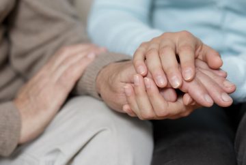 A caregiver holding someone's hands
