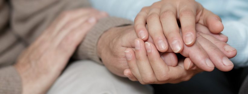 A caregiver holding someone's hands