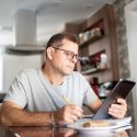 Picture of a man sitting at a table with an ipad