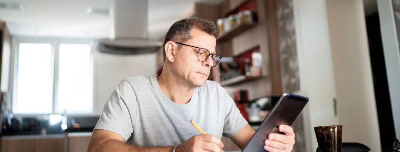 Picture of a man sitting at a table with an ipad