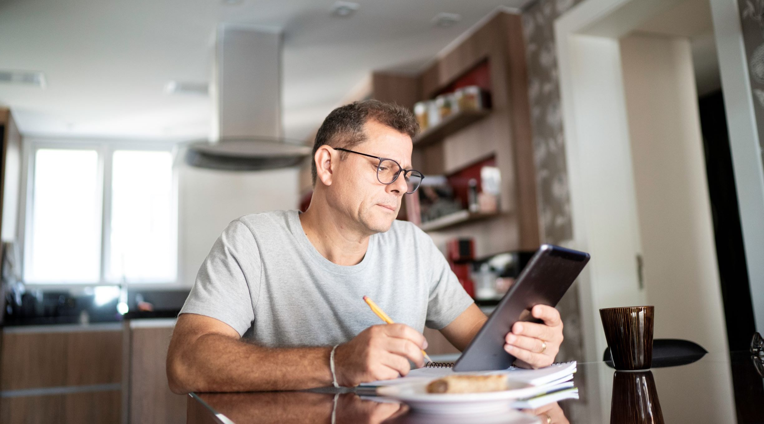 Picture of a man sitting at a table with an ipad