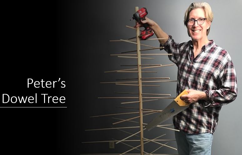 Picture of a man standing next to a tree made of dowels