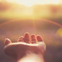 Picture of a hand reaching toward the sun